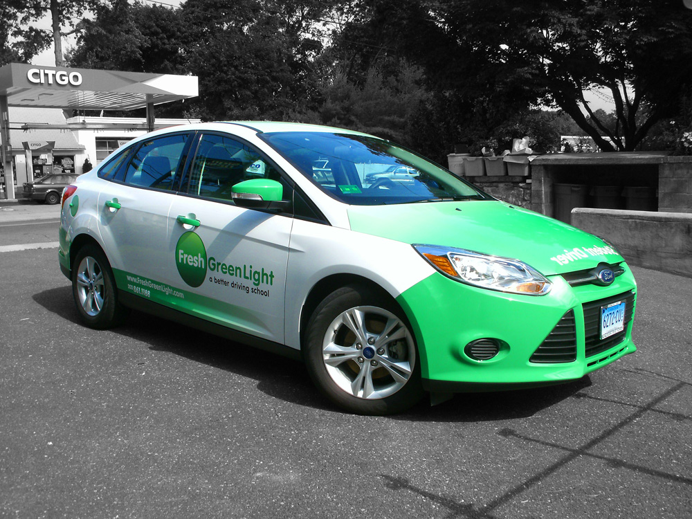 vinyl wrapped white car, containing brand identity and green accent panels