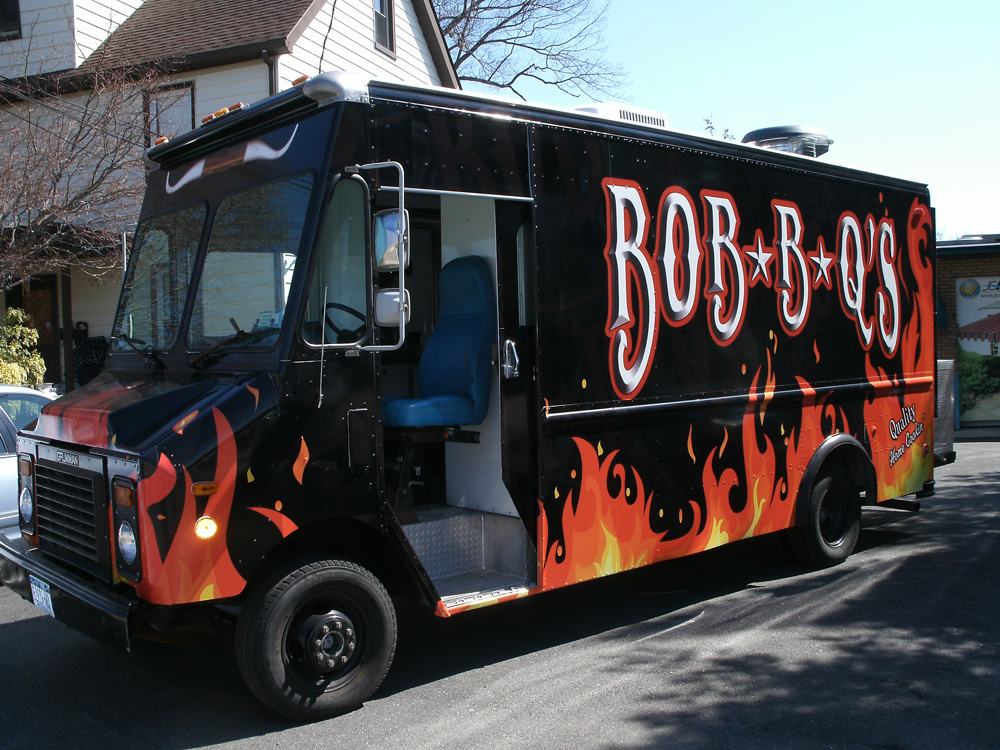 Bob’s BBQ vehicle wrap with flames on a black background