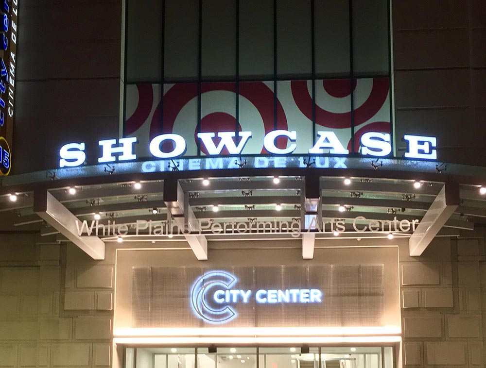 Glass entranceway canopy for White Plains Performing Arts Center’s Showcase Cinema De Lux, illuminated at night